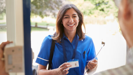 Nurse holding ID card at hospital entrance